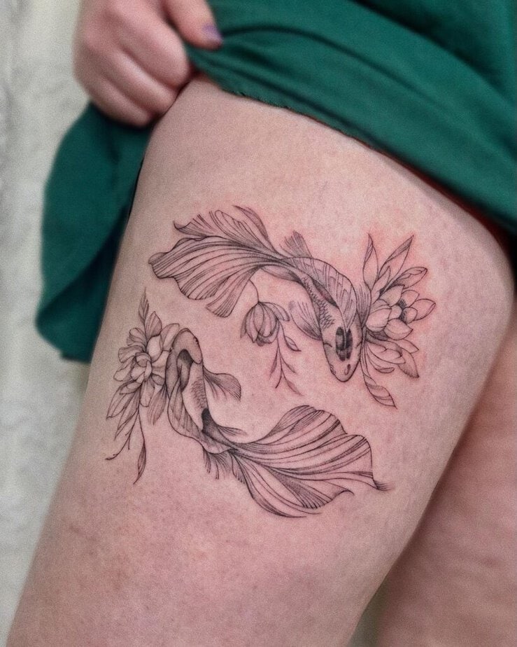 2. Un tatuaggio di pesci koi e ninfee sulla coscia