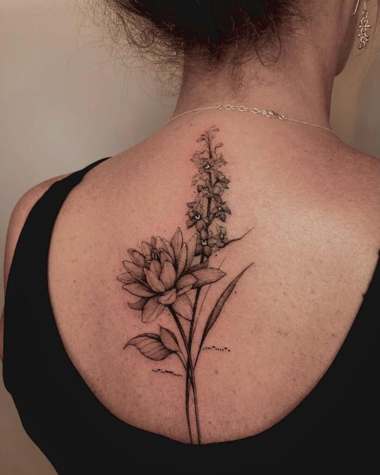 20. A water lily and larkspur tattoo on the back