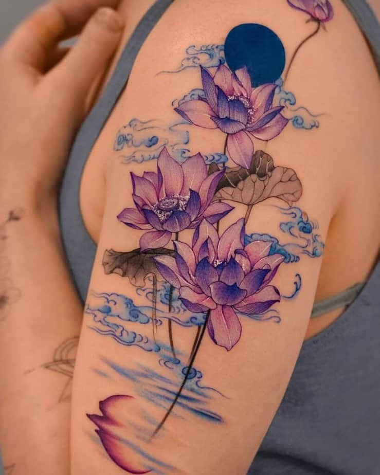 7. Tatuaggio di una ninfea viola sulla parte superiore del braccio
