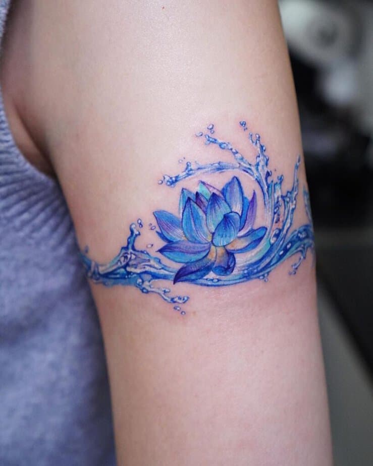 8. A blue water lily tattoo on the upper arm