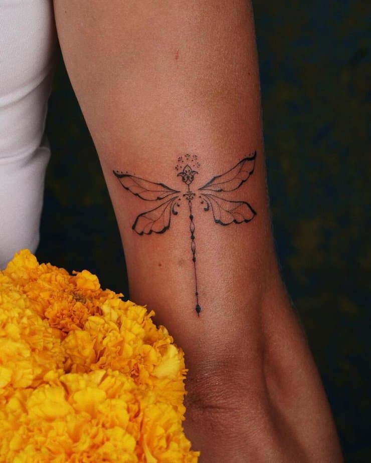 13. An ornamental tattoo of a dragonfly on the back of the arm 