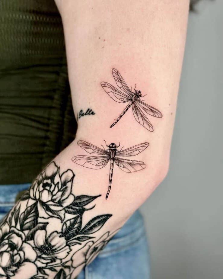 9. A tattoo of two dragonflies on the arm