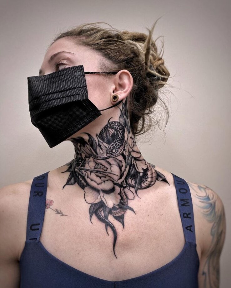 20. Un tatuaggio con fiori e serpenti sul collo