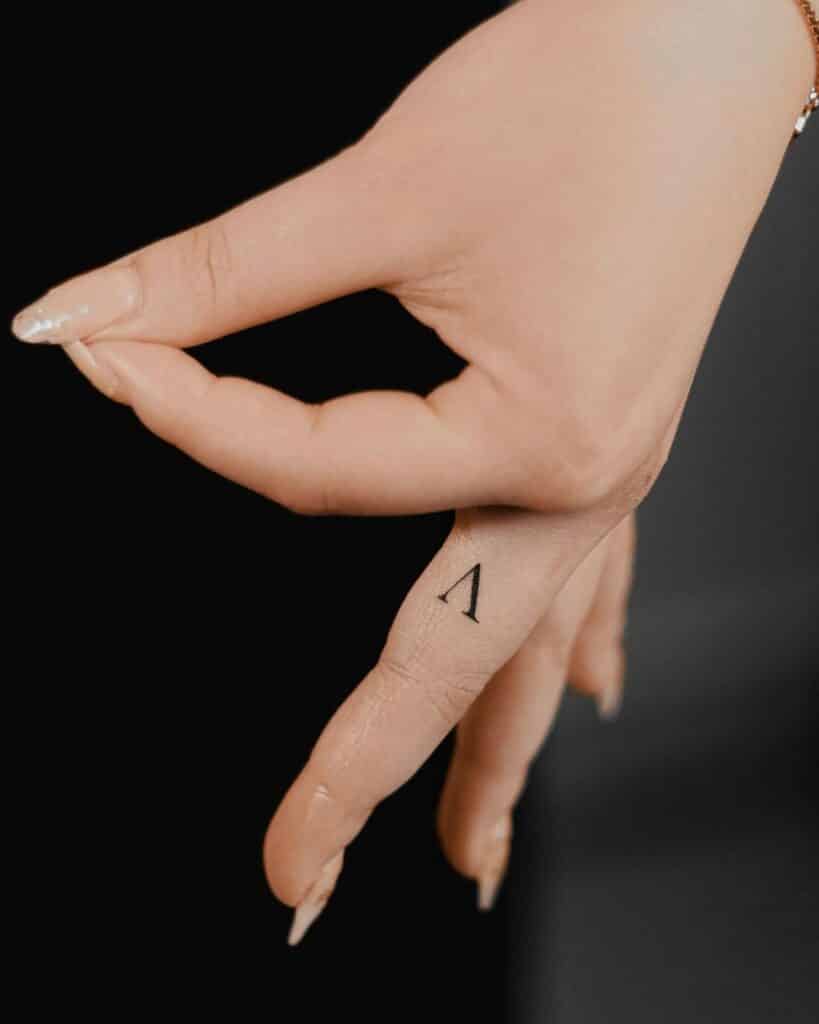 24. A letter tattoo on the finger 