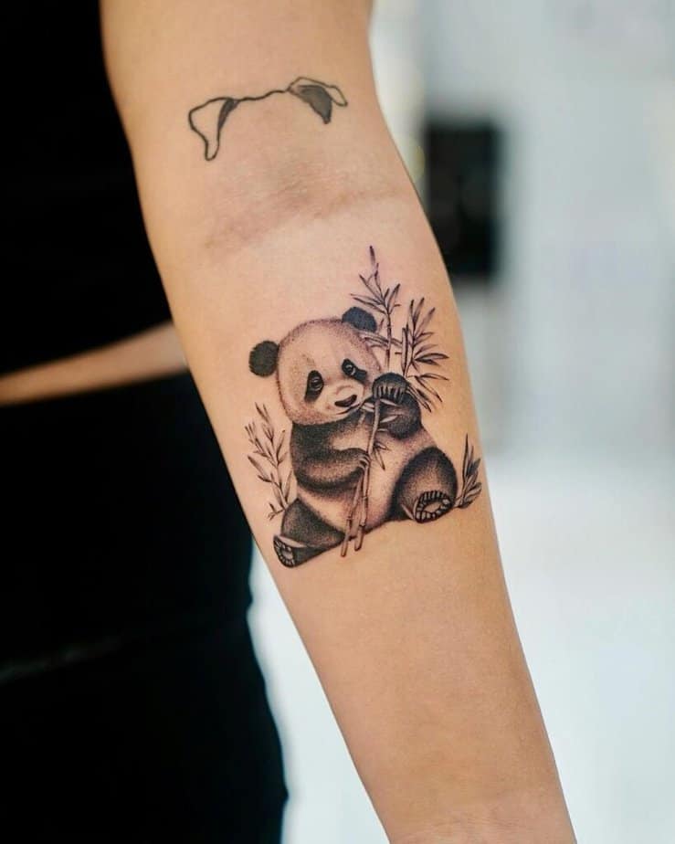 19. Un tatuaggio di un panda circondato da rami di bambù 