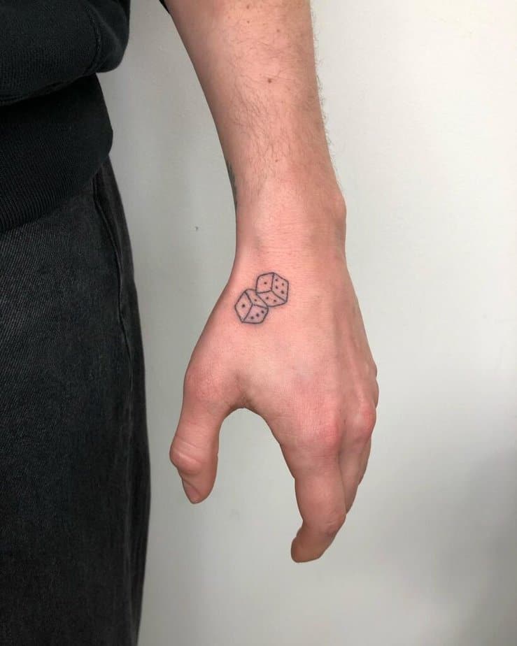 1. Tatuaggio di piccoli dadi sulla mano 