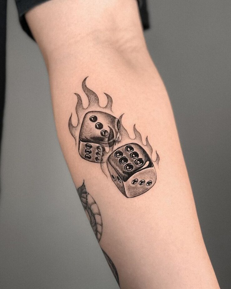 5. Tatuaggio sull'avambraccio di dadi con fiamme 