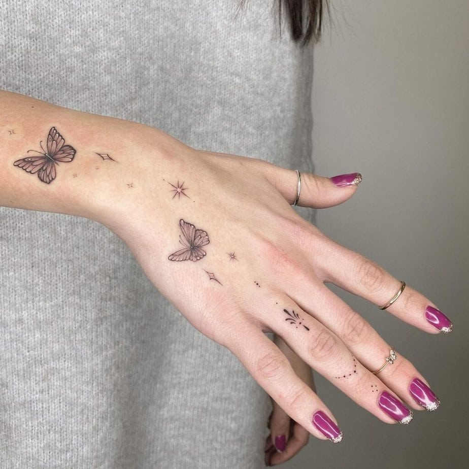 12. A finger tattoo with ornaments and butterflies 