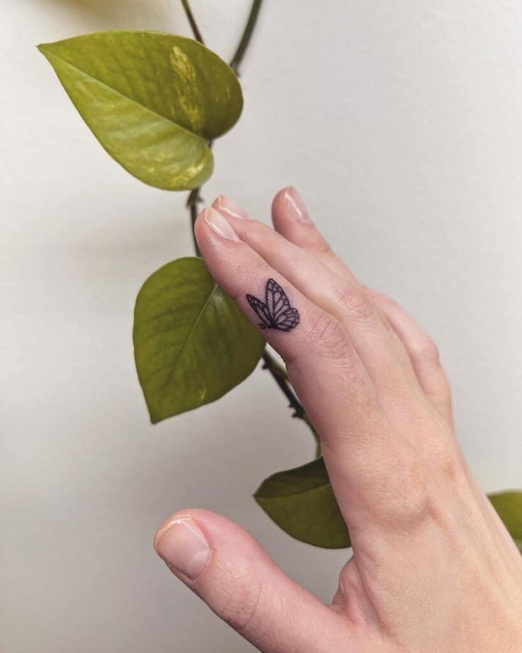 16. A hand-poked butterfly finger tattoo 