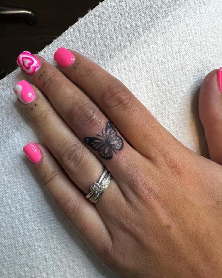 19. A butterfly finger tattoo with dots