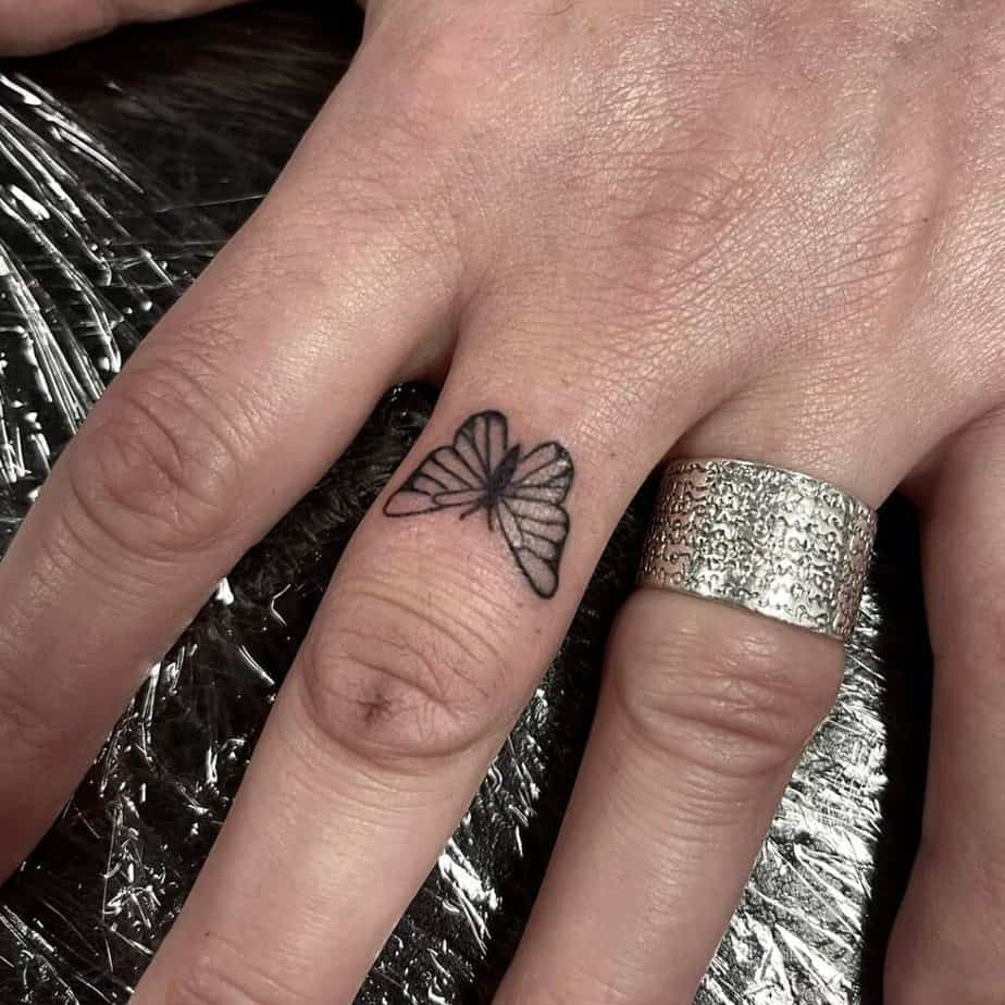 7. Un bel tatuaggio a forma di farfalla sul dito medio