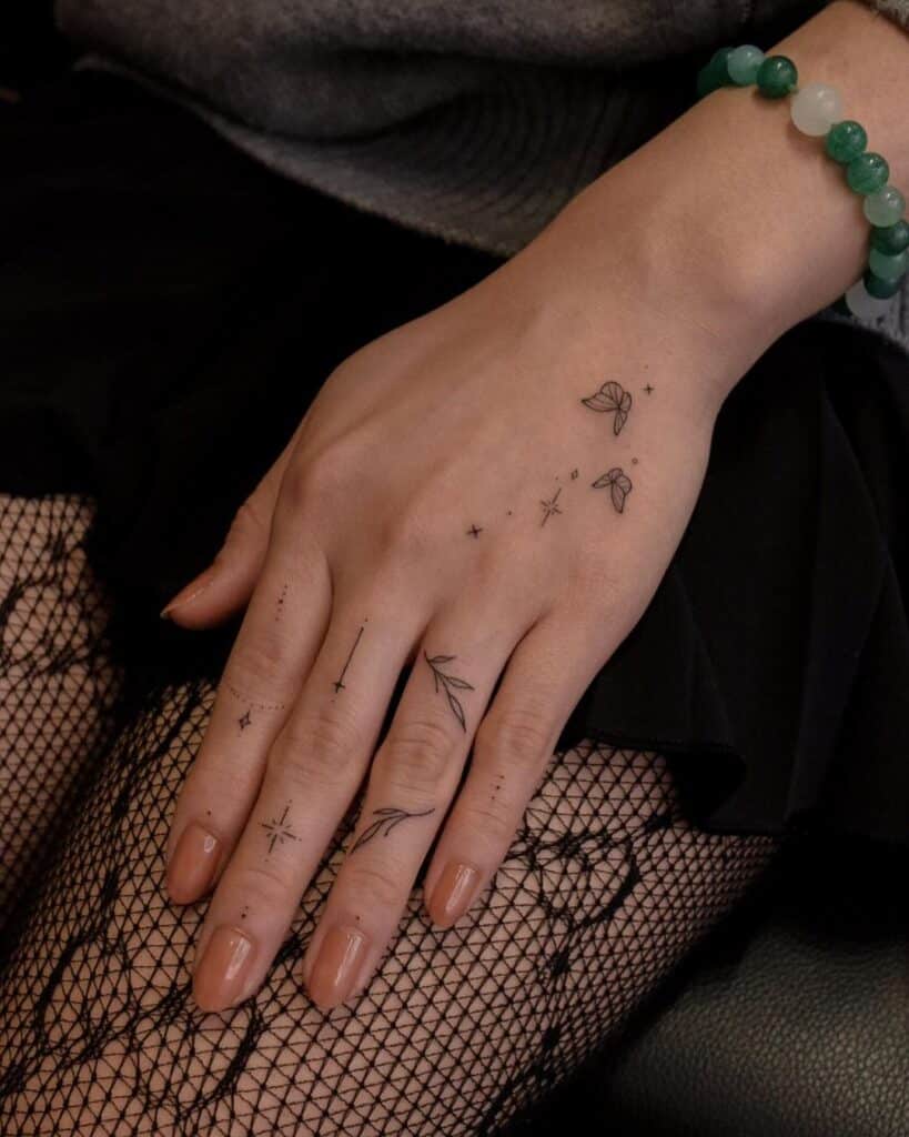8. Un tatuaggio di ornamenti per le dita con piccole farfalle 
