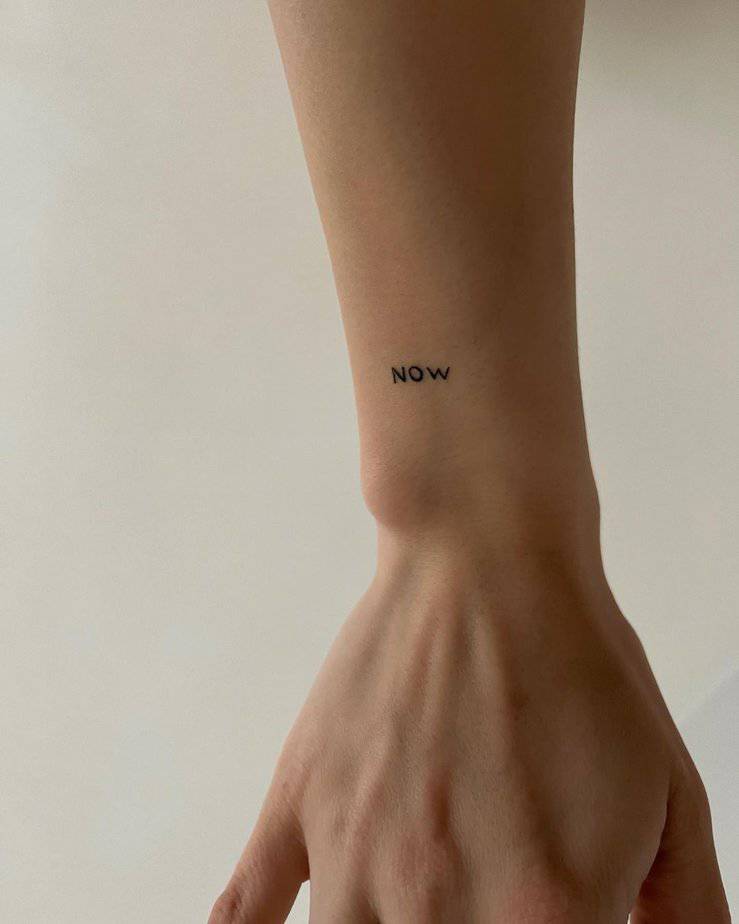 A “now” tattoo on the wrist