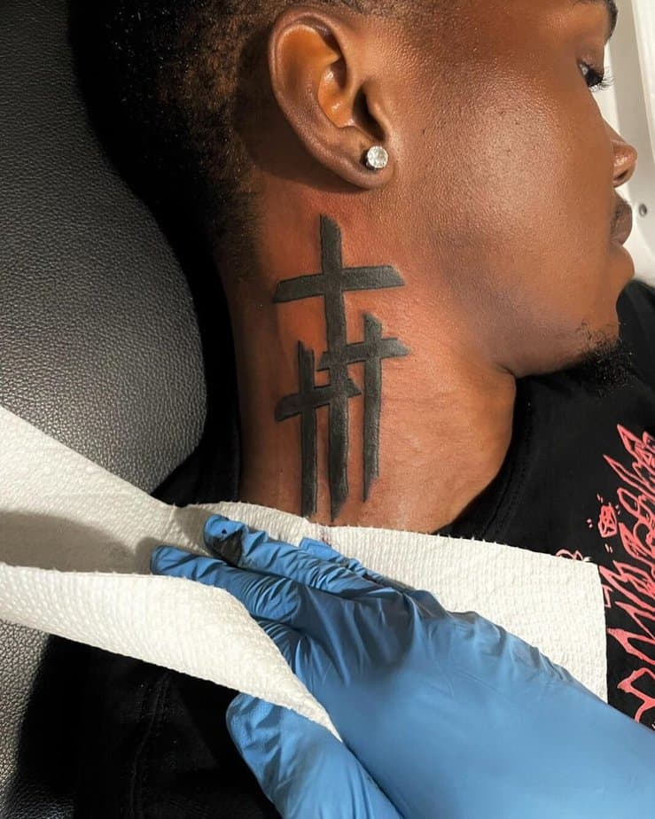 A minimalist cross tattoo on your neck