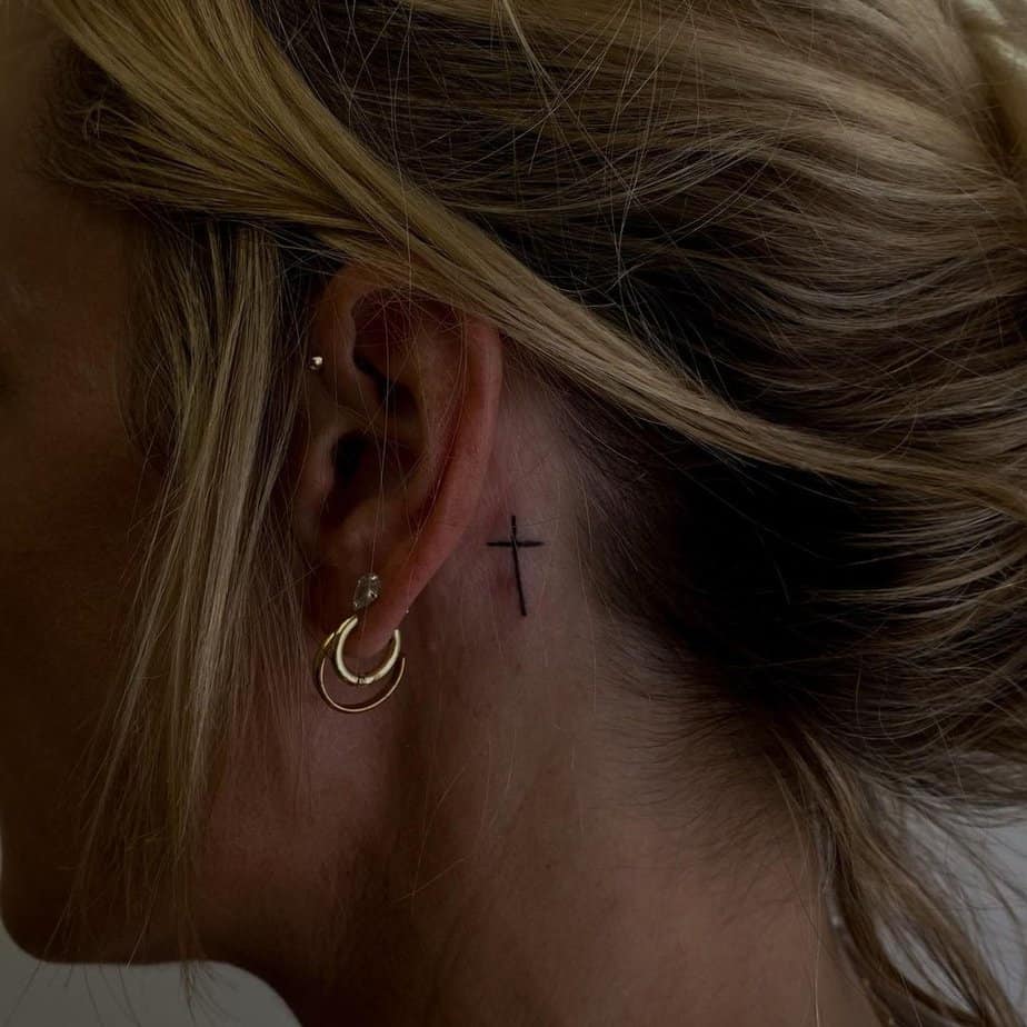 A cute cross tattoo on your ear