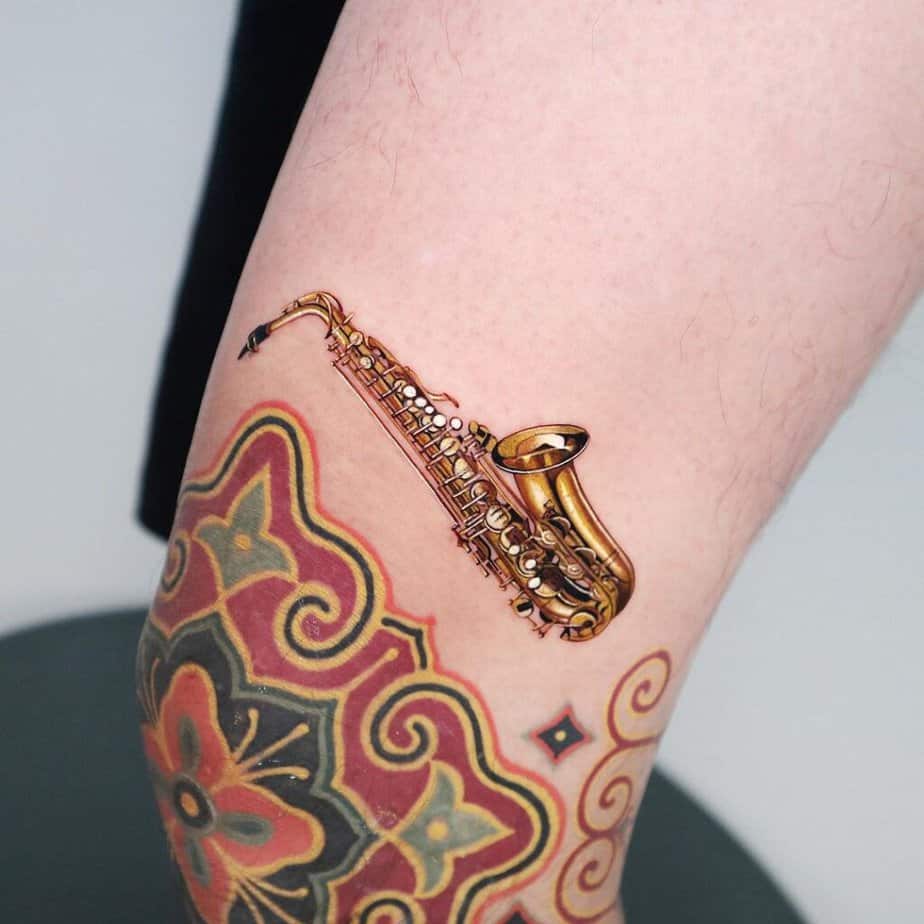 20. A colored saxophone tattoo above the knee 