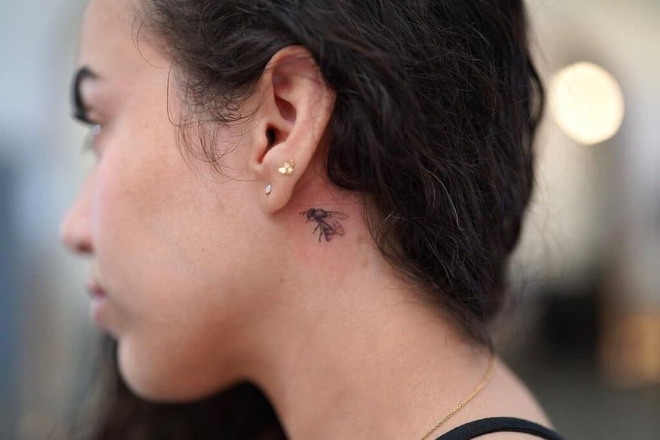 A bee tattoo behind the ear