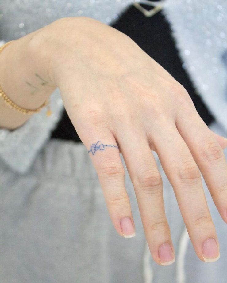 A blue ribbon tattoo on the finger