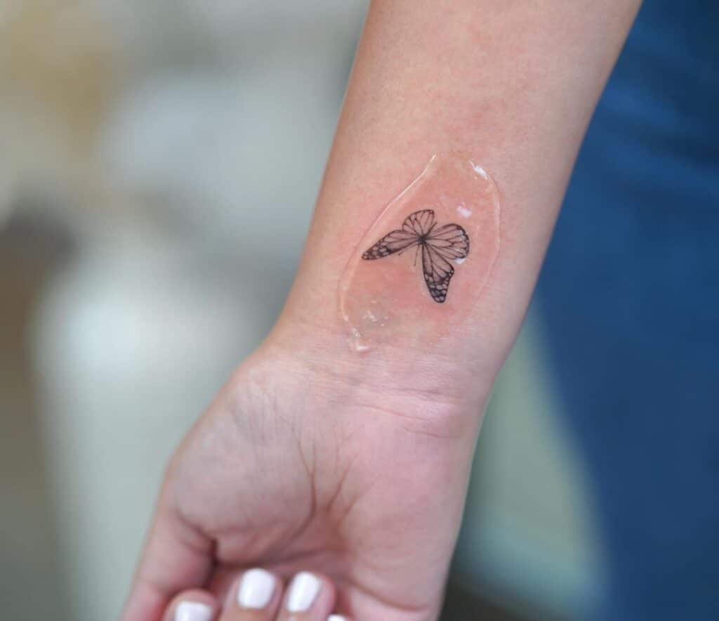 Un tatuaggio a forma di farfalla sul polso