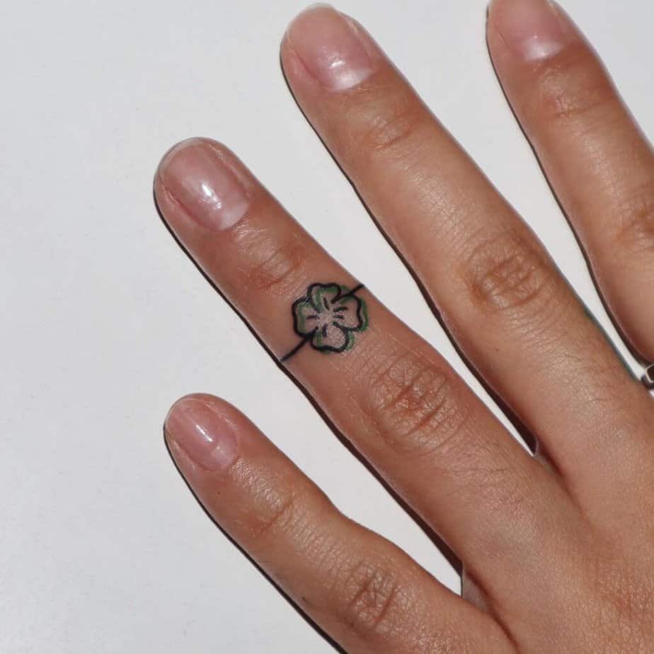 A clover tattoo on the ring finger