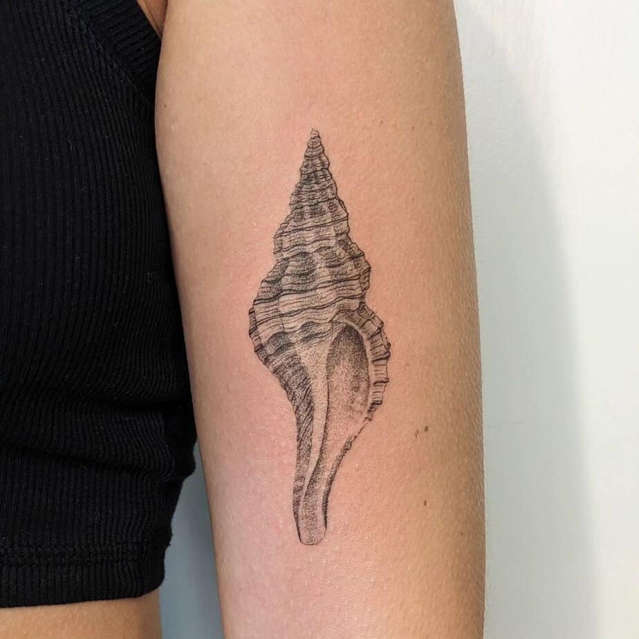 1. Un tatuaggio a conchiglia sulla parte superiore del braccio
