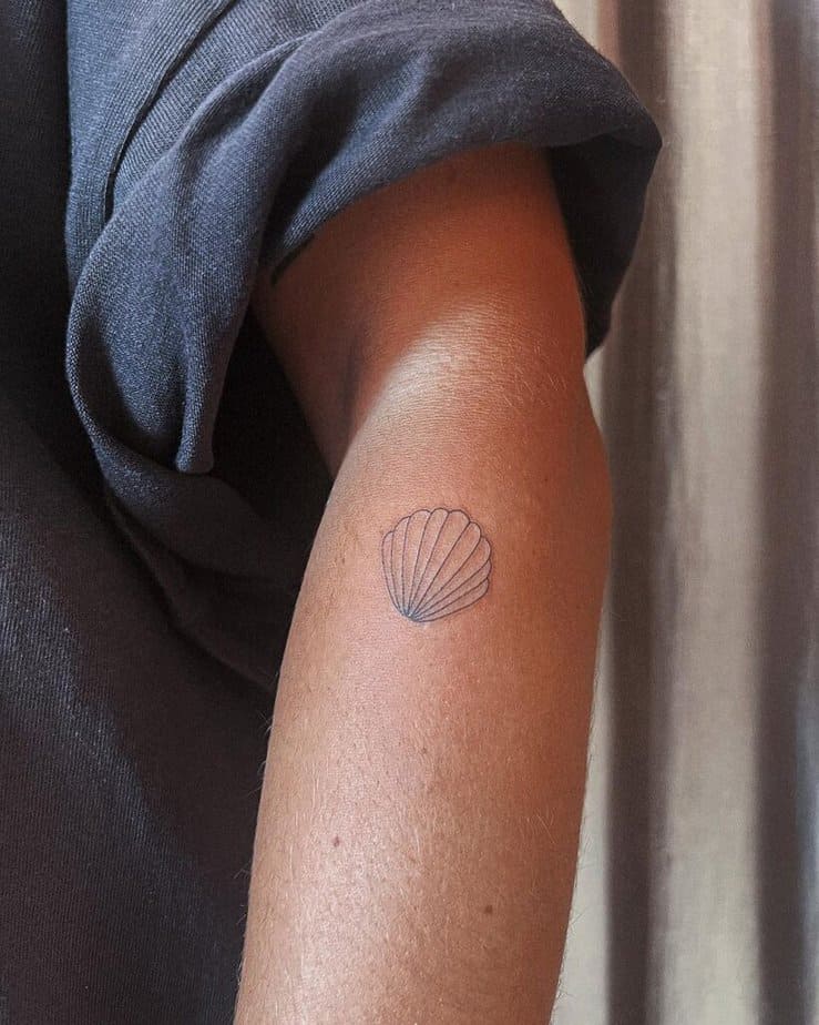 A dainty and delicate tattoo of a shell