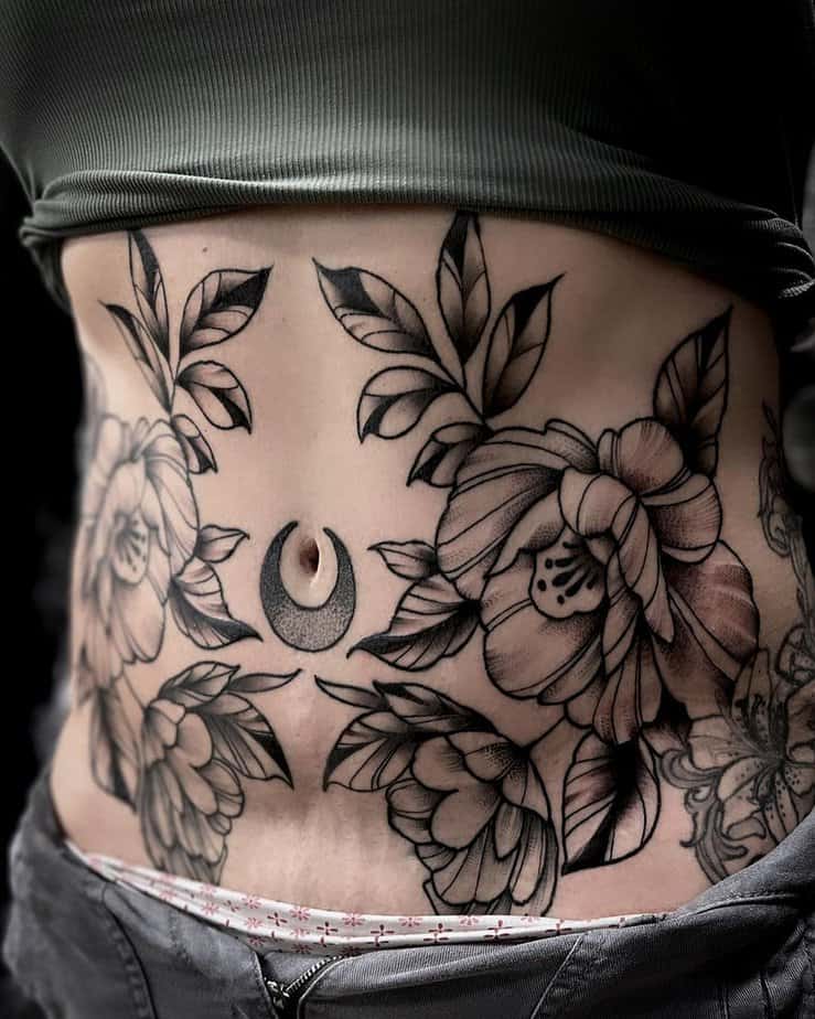 13. A floral tummy tuck tattoo with a moon
