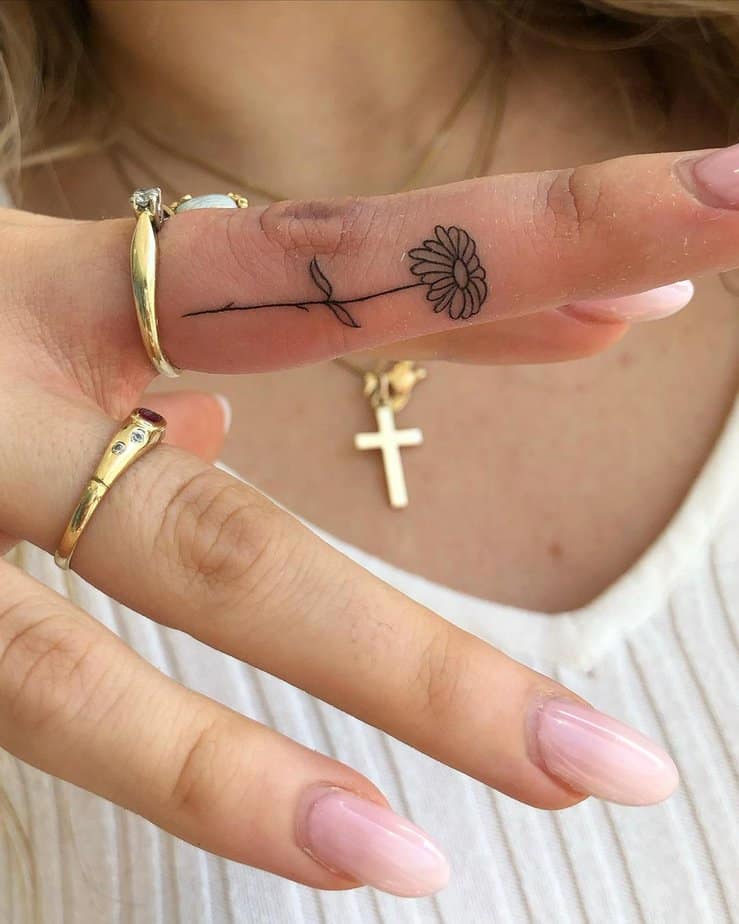 Un tatuaggio a forma di fiore sul dito