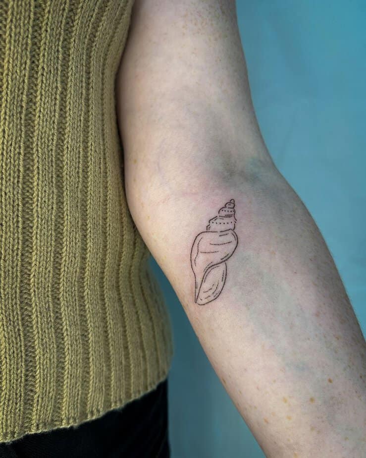 6. Un tatuaggio a conchiglia inciso a mano