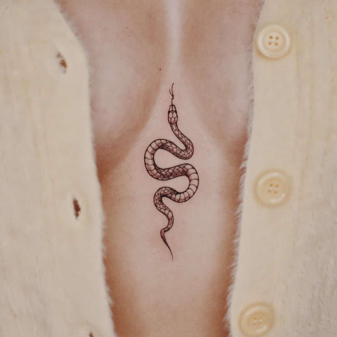 A minimalist snake sternum tattoo