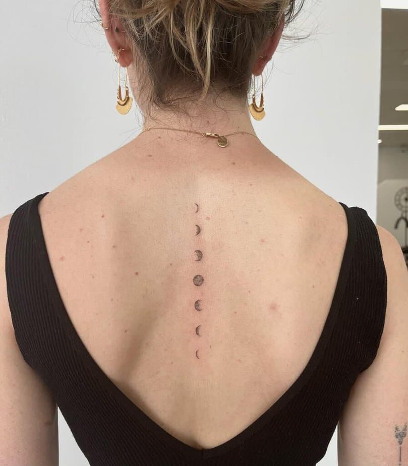 A moon phase spine tattoo