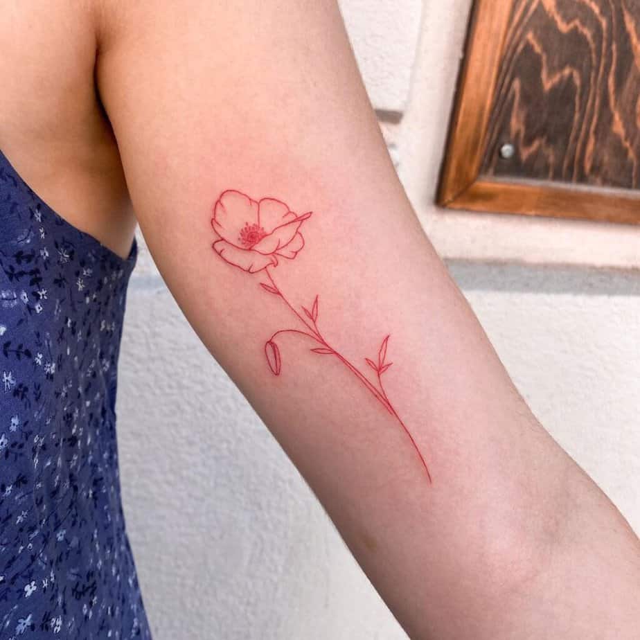 A red ink poppy flower tattoo