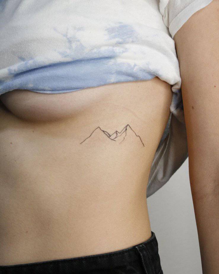14. A simple and sleek line-art mountain tattoo
