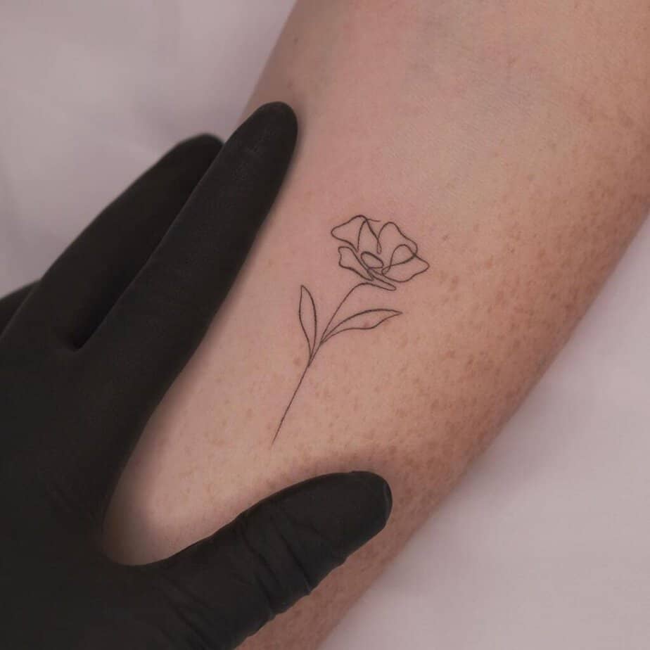 A single-line poppy flower tattoo