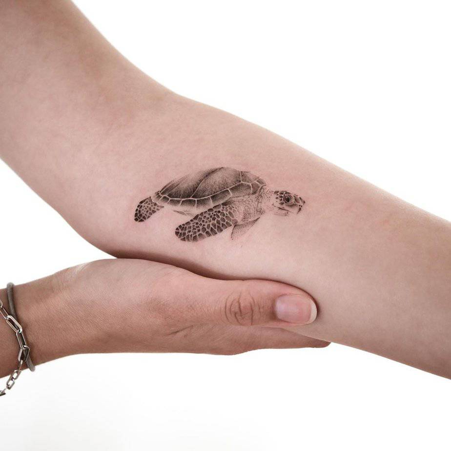 6. A soft and sleek sea turtle tattoo on the forearm
