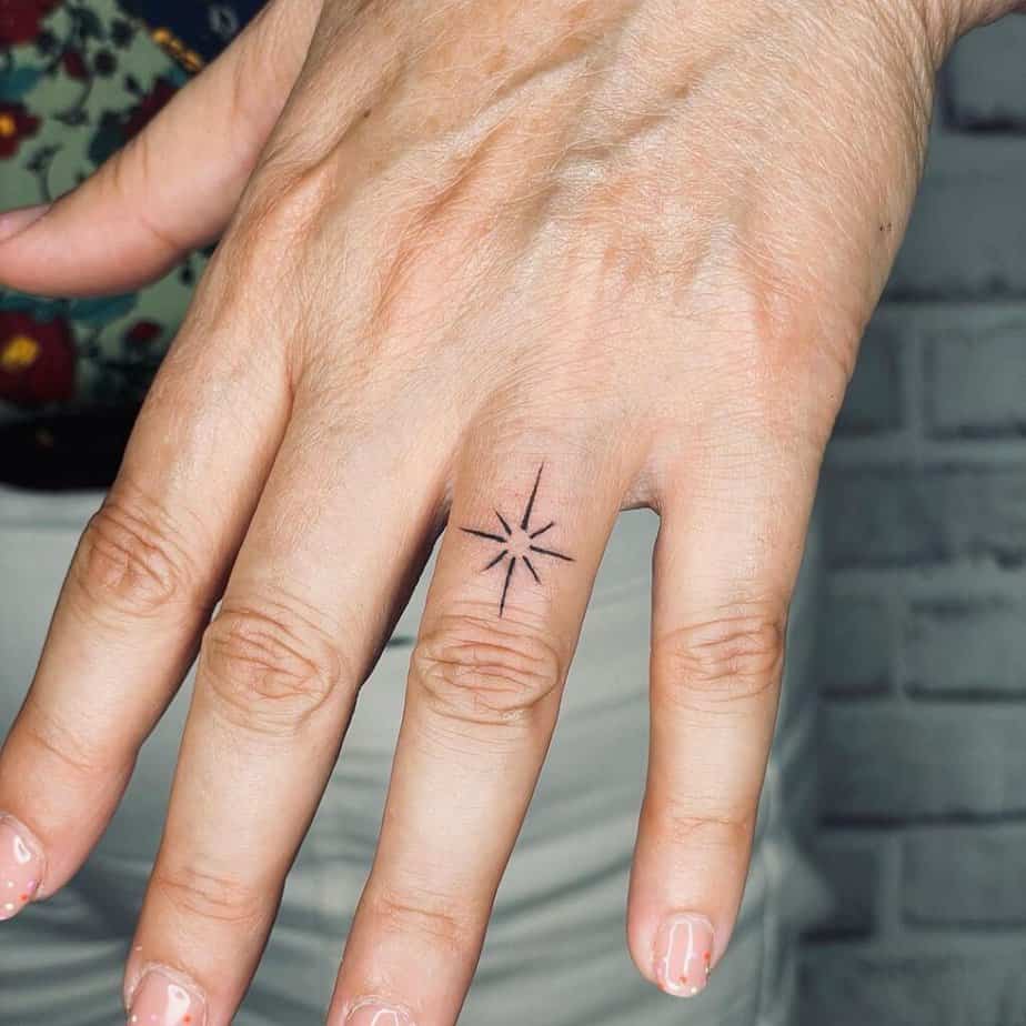 A sparkle tattoo on the ring finger