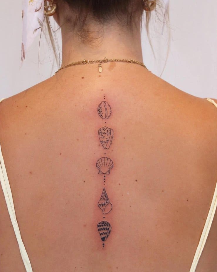 7. Un tatuaggio sulla colonna vertebrale raffigurante una collezione di conchiglie