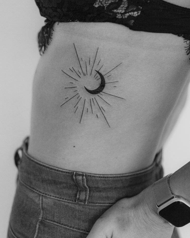 A sun and moon tattoo on the ribs