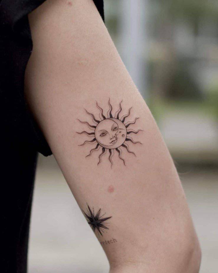 A sun and moon tattoo on the upper arm