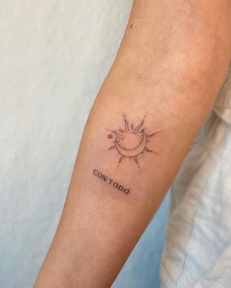 A sun and moon tattoo with a mantra
