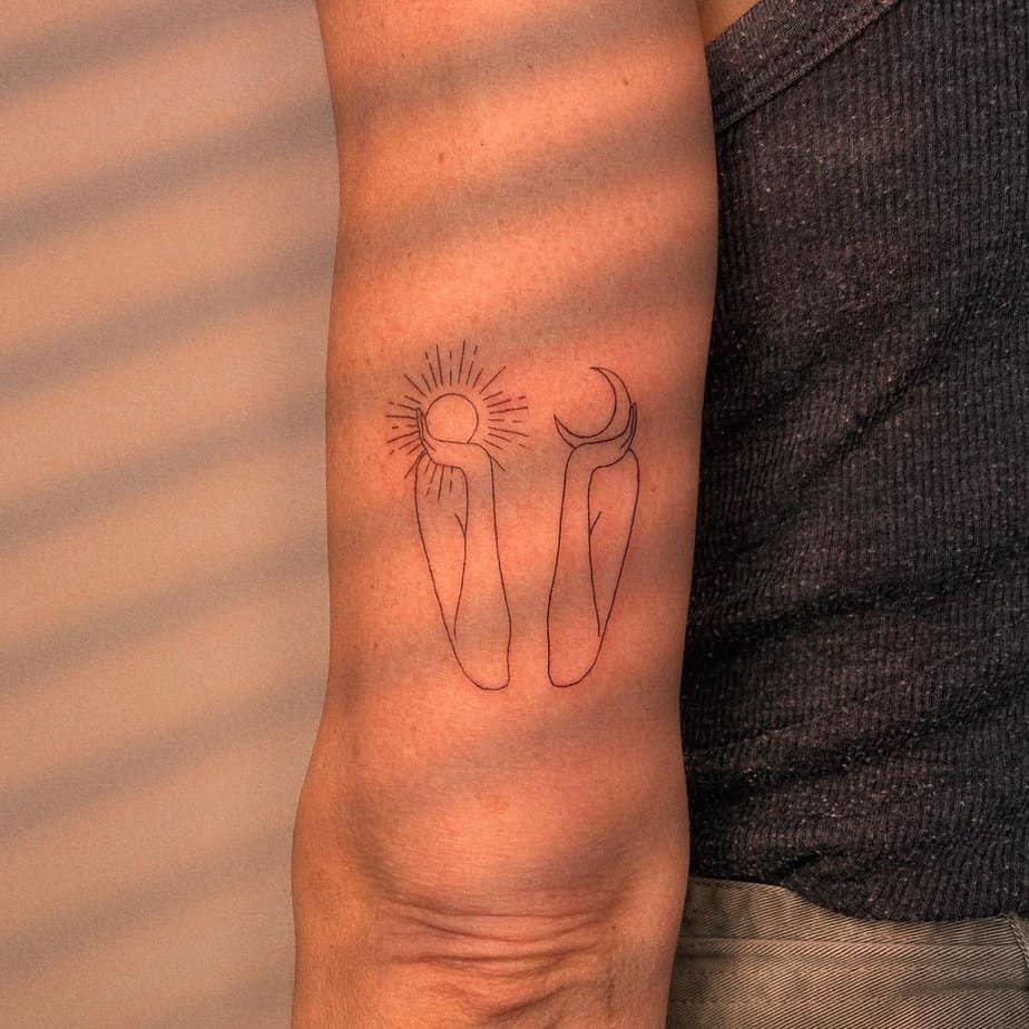 A tattoo of a person holding the sun and the moon