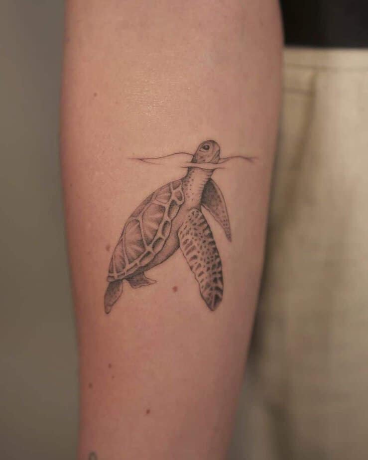 12. Un tatuaggio di una tartaruga marina che esce dall'acqua