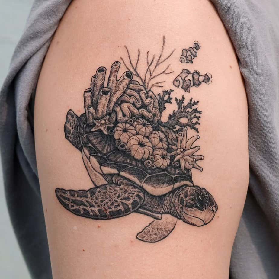 10. A tattoo of a sea turtle with corals and fish on the upper arm
