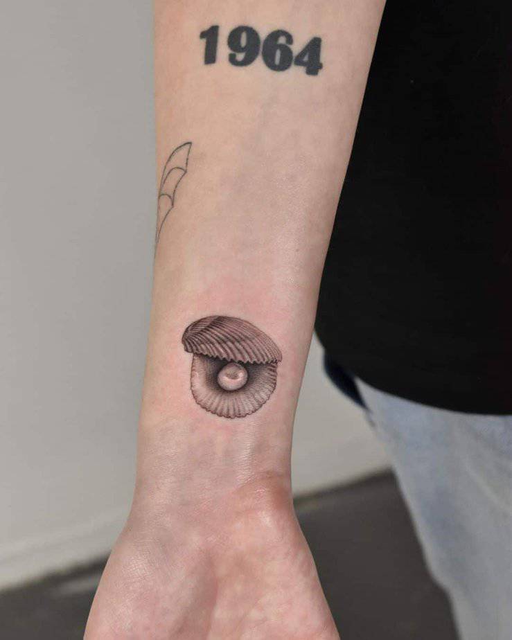 24. Un tatuaggio di una conchiglia con una perla