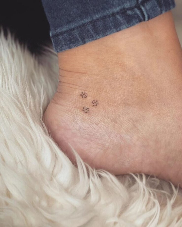A tattoo of paw prints on the foot