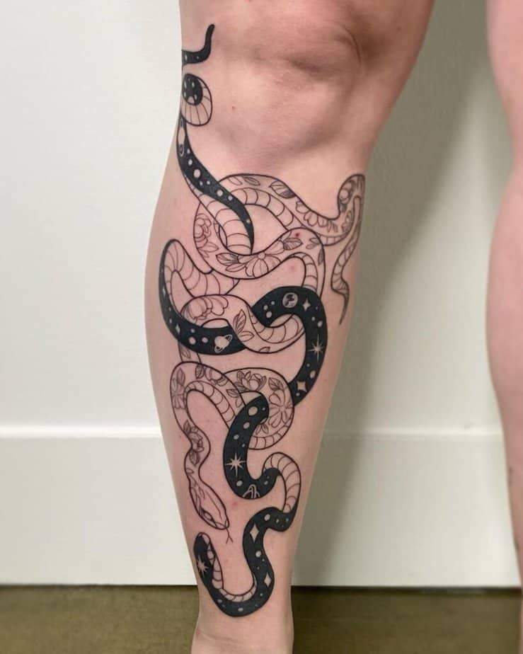 A tattoo of two snakes on the shin