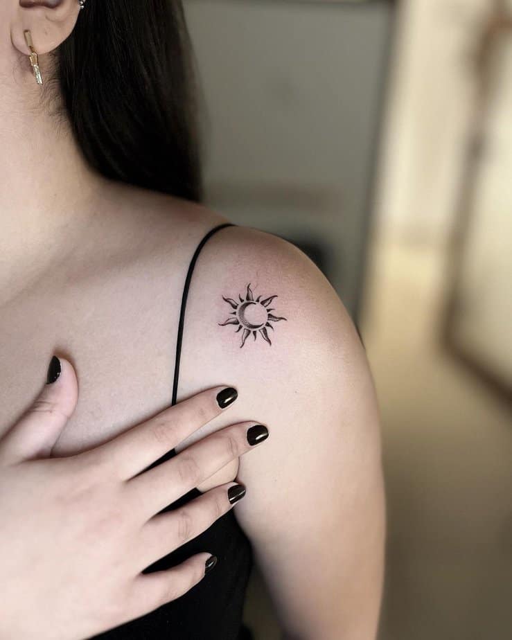 A tiny sun and moon tattoo on the shoulder