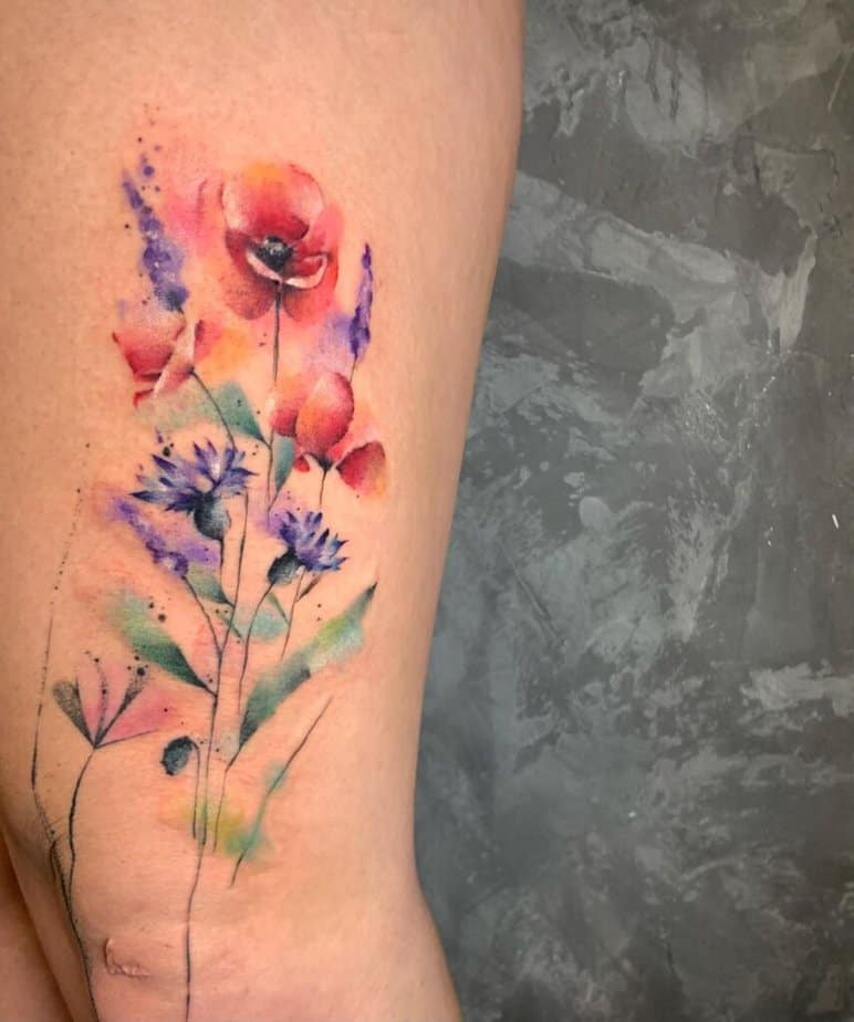 A watercolor poppy flower tattoo