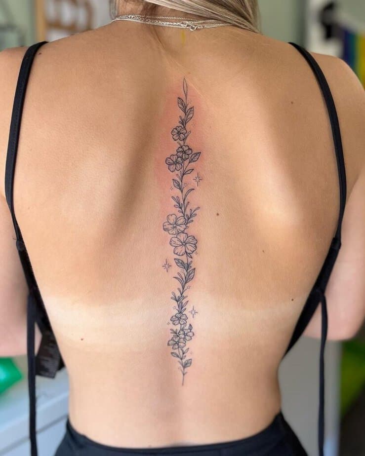 Un elegante tatuaggio floreale sulla colonna vertebrale