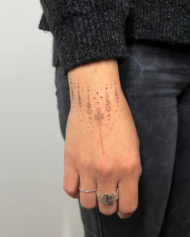 Un tatuaggio ornamentale che si estende dal polso fino alle dita.